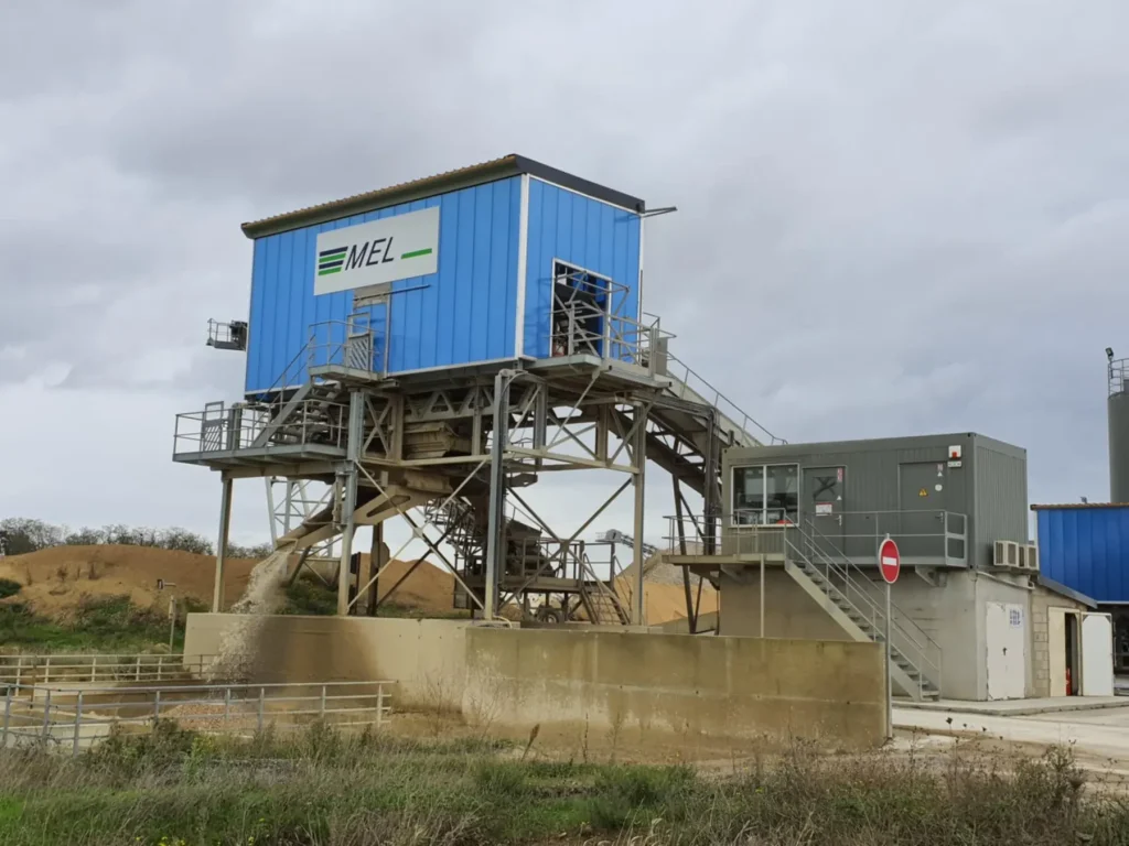 Cabine bleue au logo MEL en haut d'une tour de criblage, passerelles et escaliers métalliques