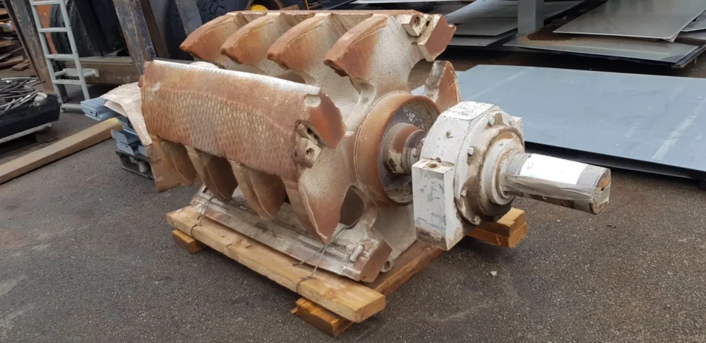 Autre rotor de broyeur et son arbre posés sur une palette, palier monté en bout d'arbre